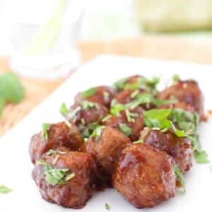 GLAZED MEATBALLS ON A PLATE GARNISHED WITH CILANTRO