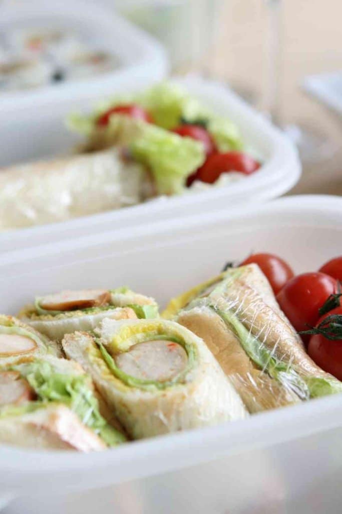 SANDWICHES AND GRAPES IN PLASTIC LUNCH CONTAINERS