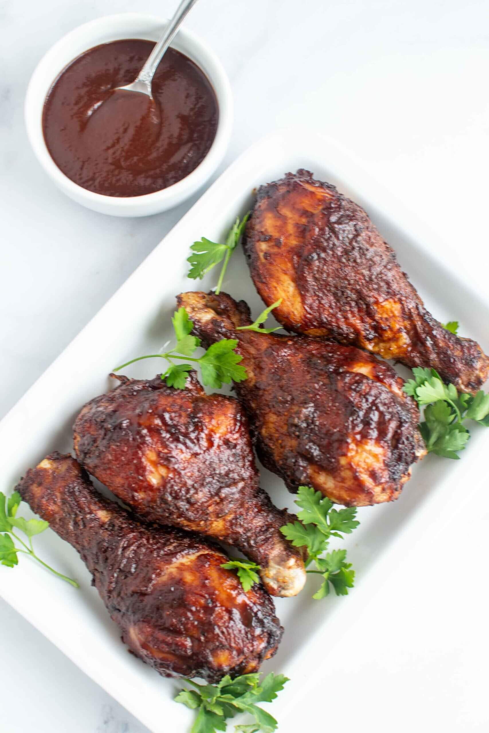 4 Air Fryer BBQ chicken legs on a plate with cilantro