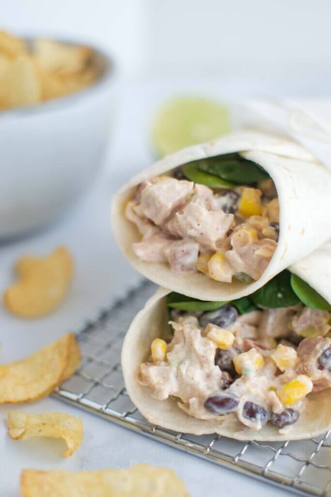 Two tex mex chicken wraps with potato chips