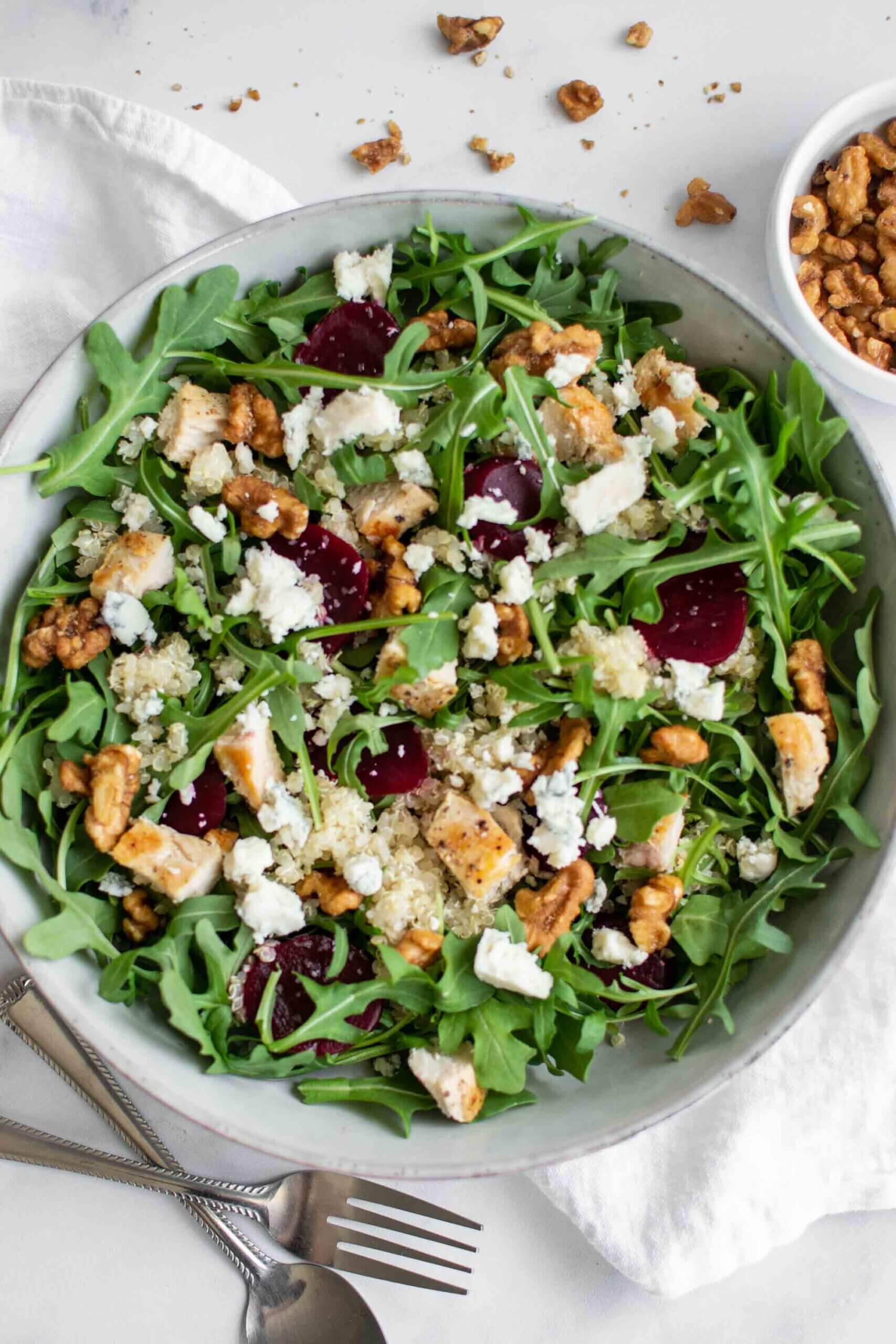 Quinoa and arugula salad in a bowl with beets, chicken and gorgonzola cheese