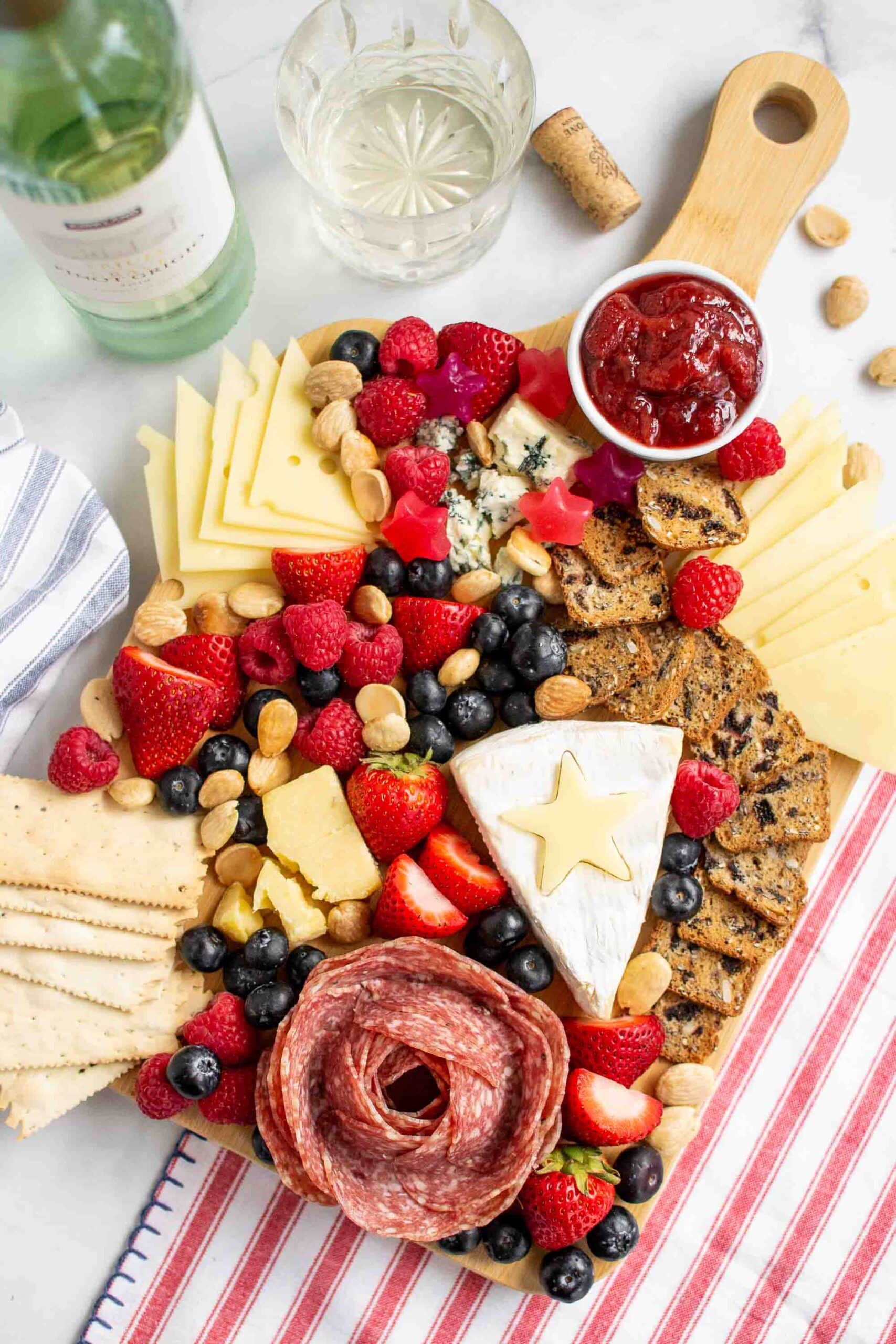 Red white and blue colored Patriotic Charcuterie Board with a wine glass and bottle