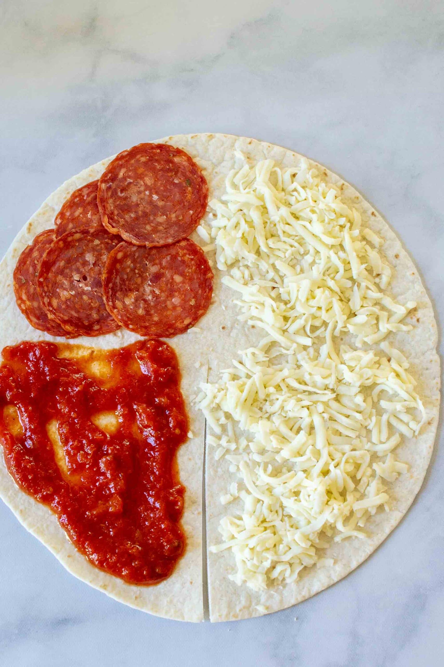 Step 1 of making a Pizza Tortilla Wrap or Pizza "Tortilla Trend." Add ingredients. 