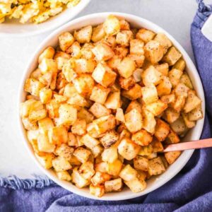 diced hash brown potatoes in a bowl with a blue napkin in the background