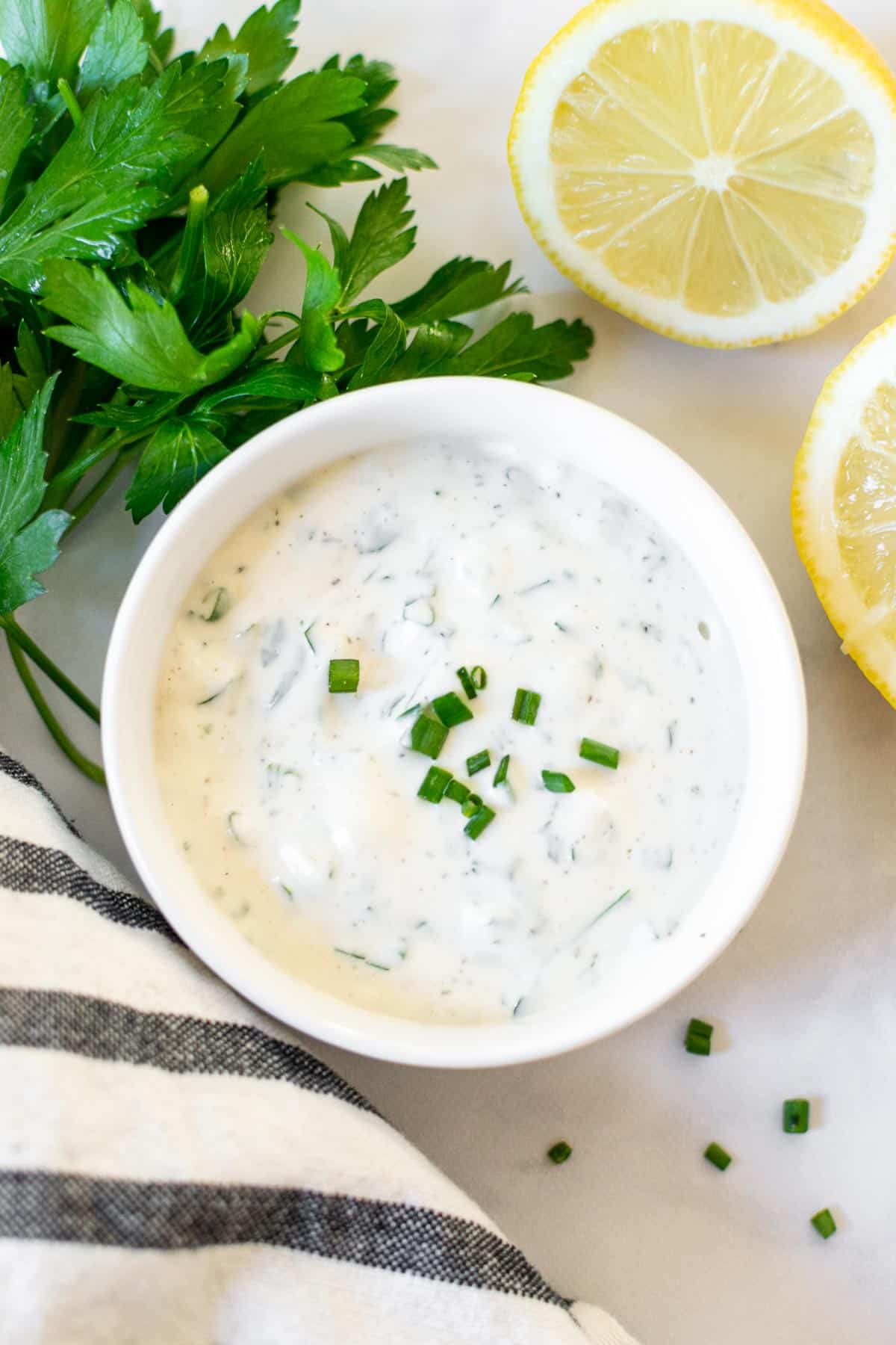 Easy homemade ranch dressing in  small white bowl, sprinkled with chives