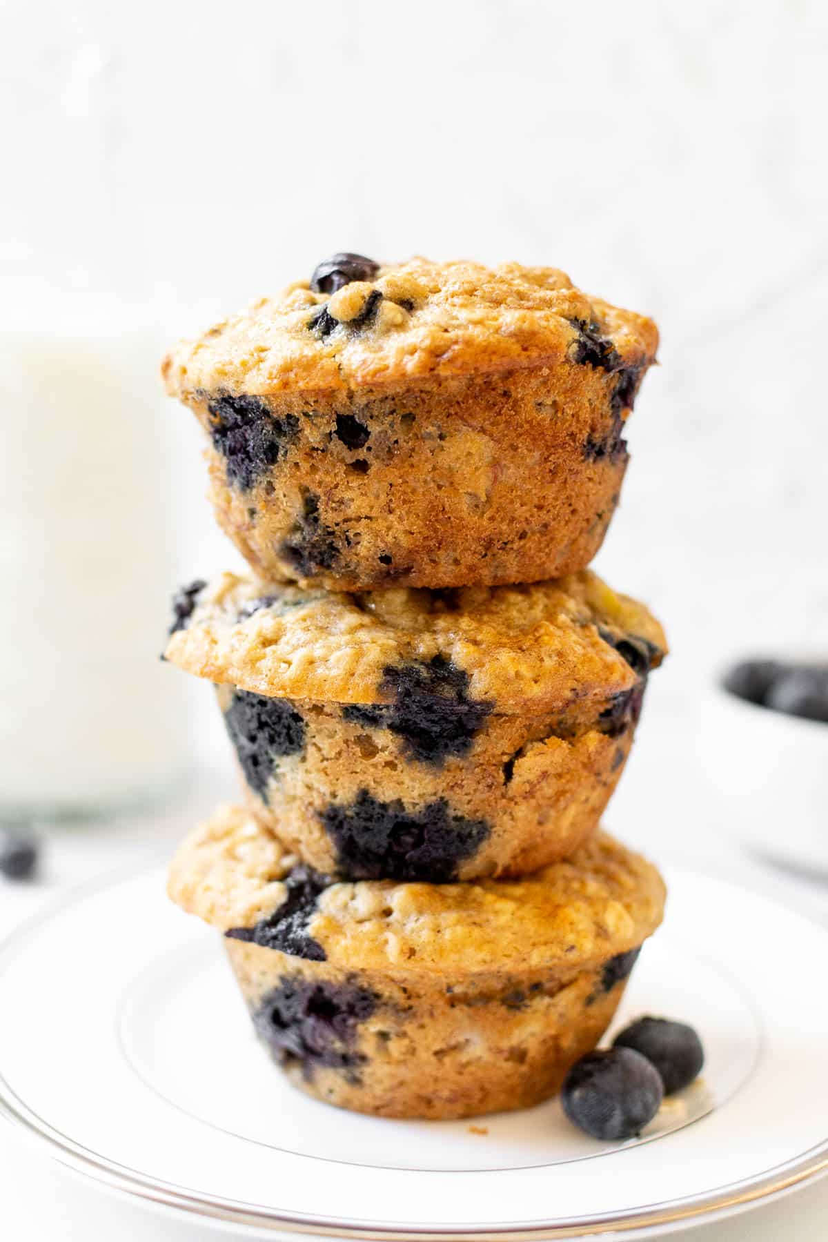 3 banana blueberry oatmeal muffins stacked on top of one another