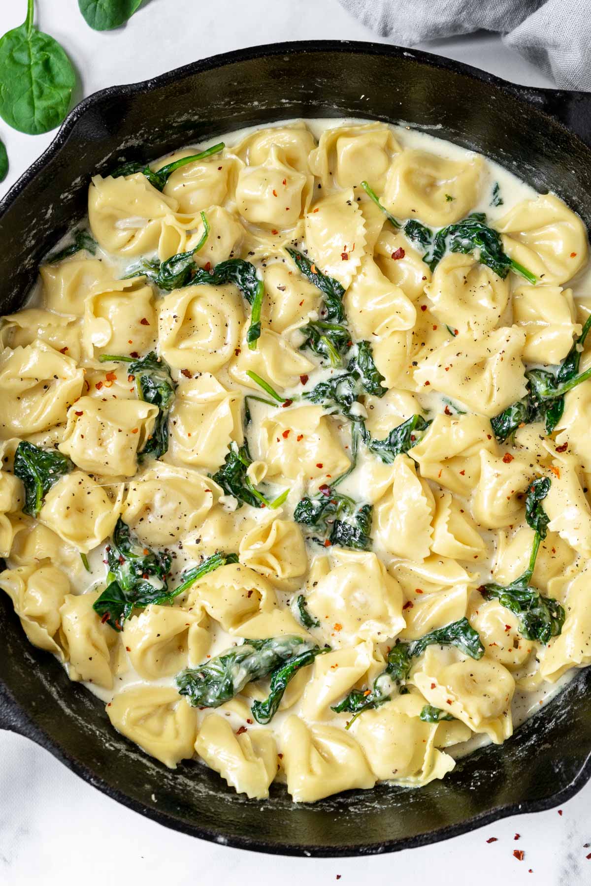 Asiago tortellini in a cast iron pan with spinach