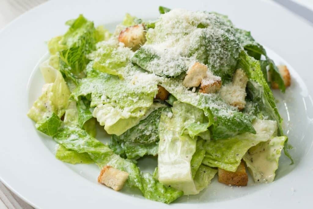 Salad sides for sloppy joes: caesar salad on a white plate