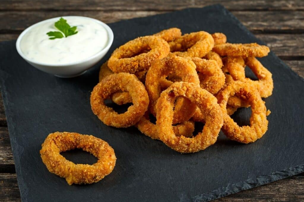Onion rings on a plate with ranch dressing
