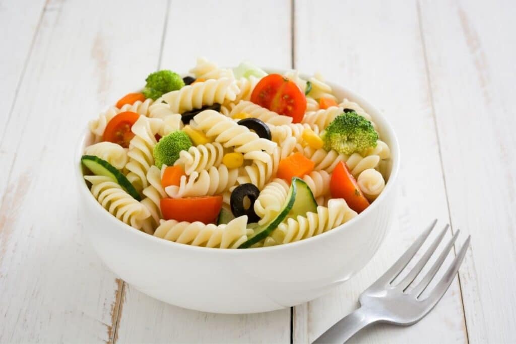 A simple pasta salad in a bowl with a fork