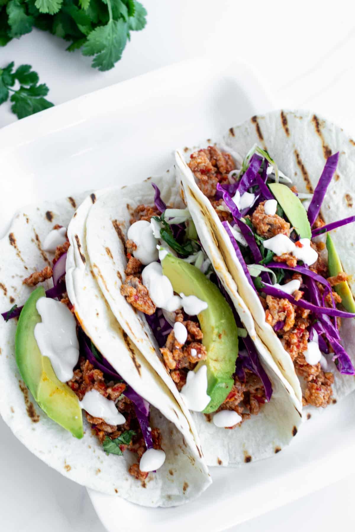 3 spicy ground pork tacos on a plate