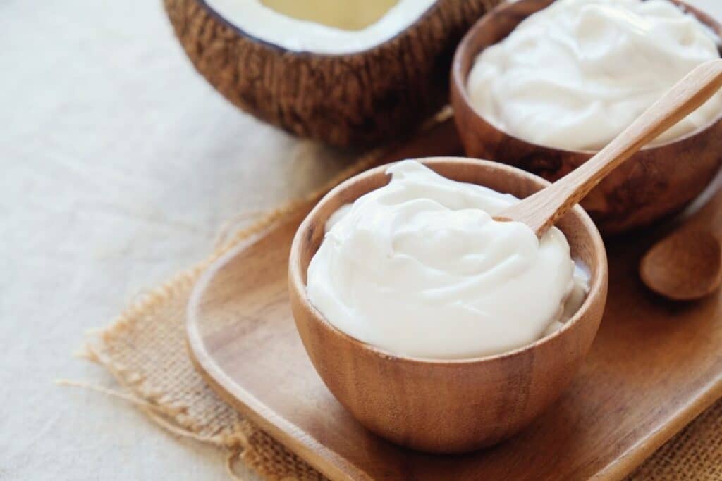 A small wooden bowl of Greek yogurt with a spoon.