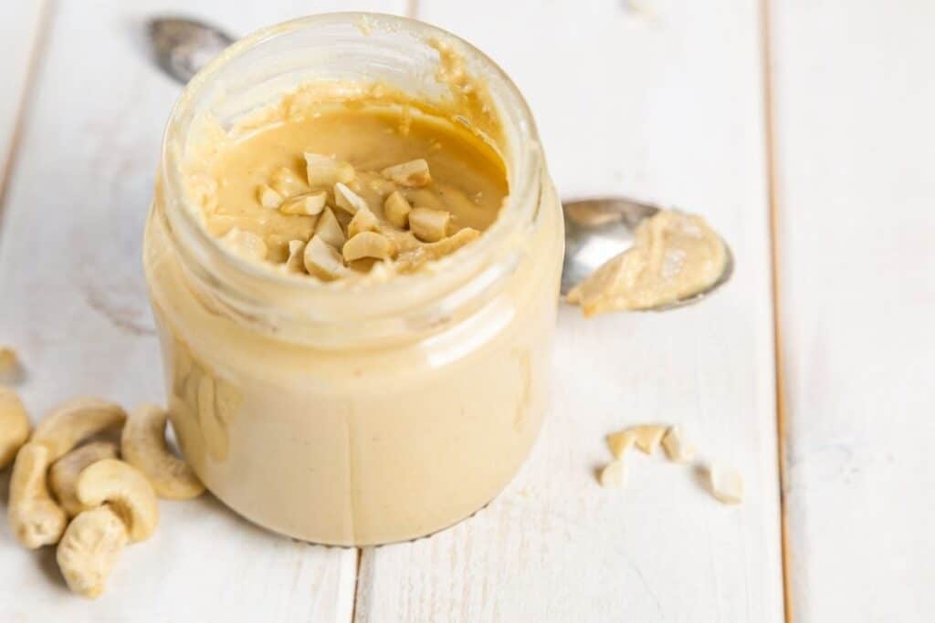 One of the best substitutes for almond butter is cashew butter. In a jar with a white background.