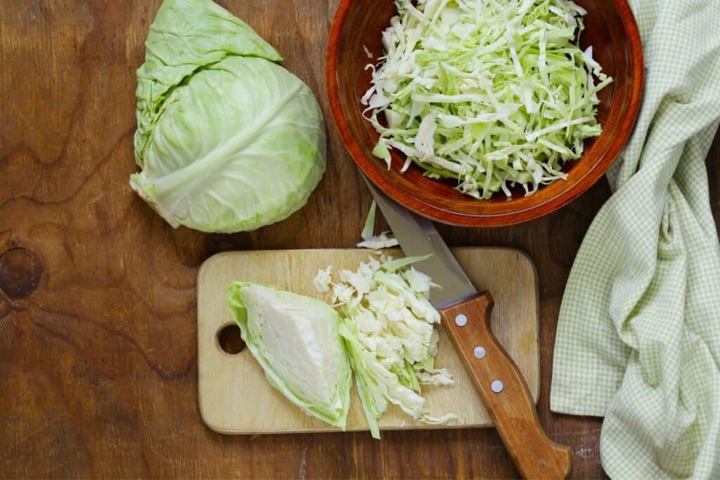 Cabbage being cut on a cutting board
