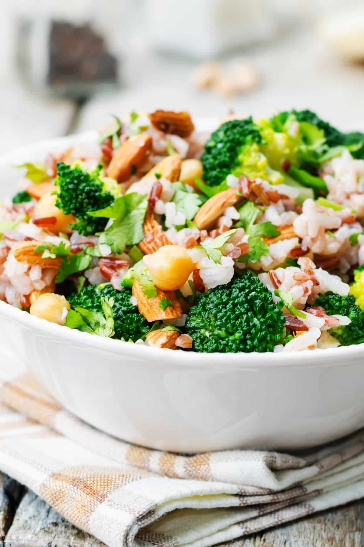 24 Easy Sides for Grilled Cheese: Broccoli salad in a white bowl with bacon and red onions.