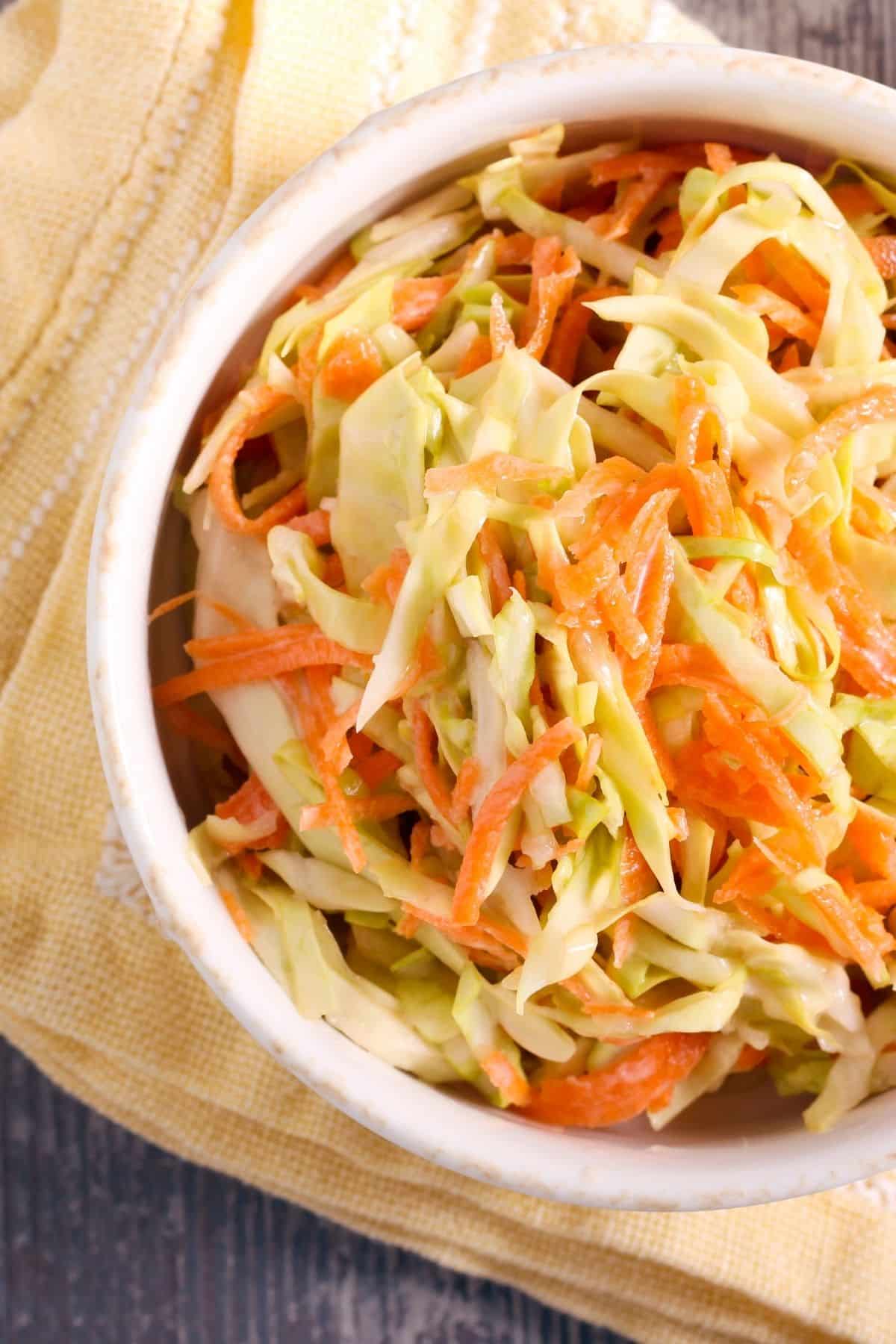 Close up of cole slaw in a white bowl.