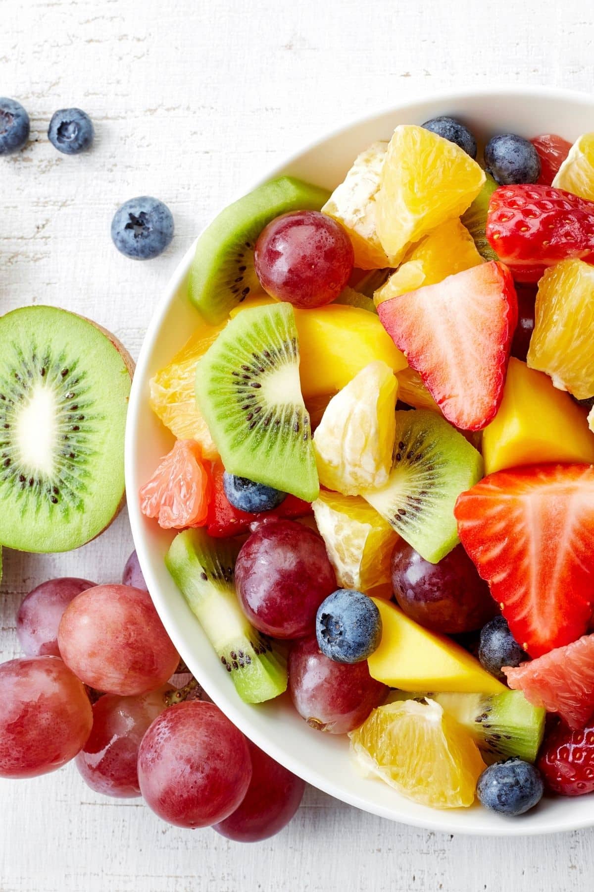French fruit in a bowl: kiwis, strawberries and grapes.