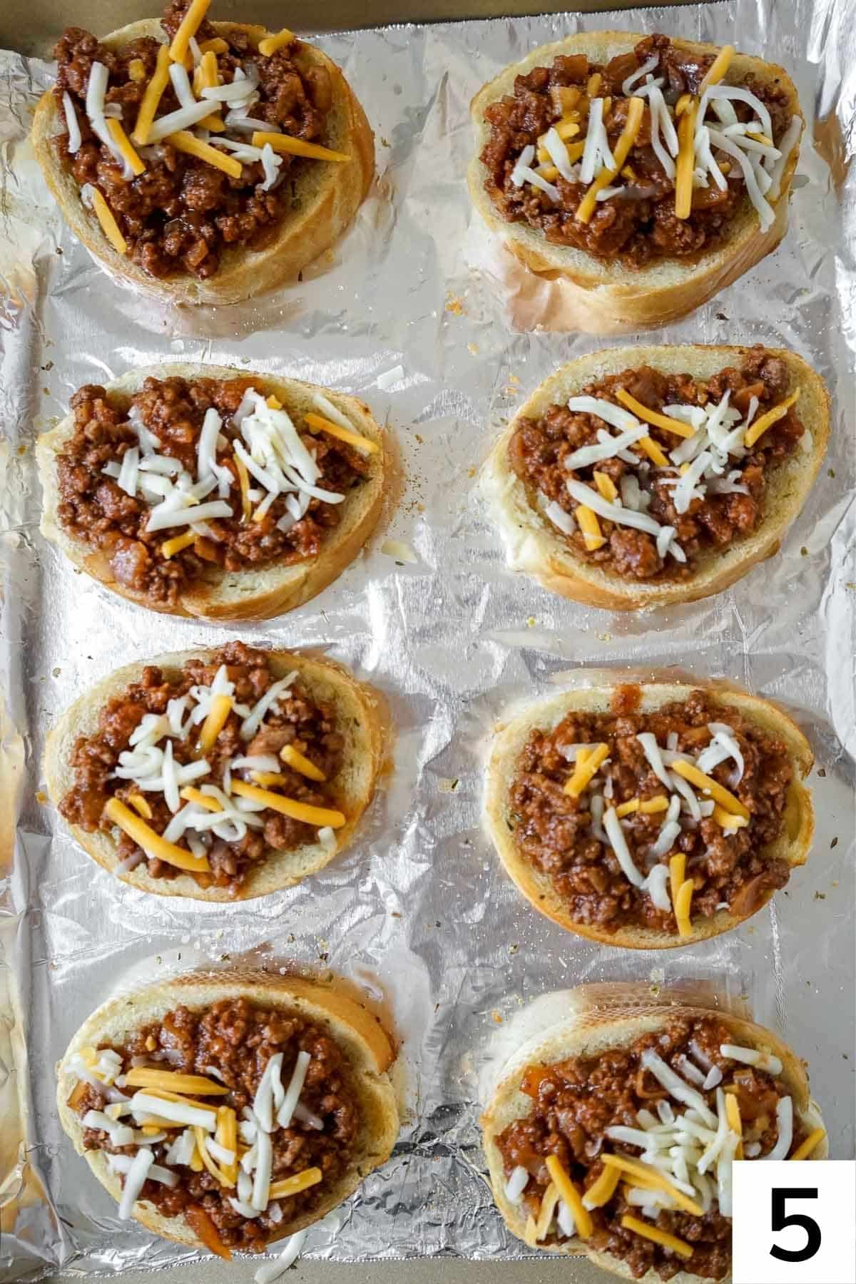 Eight slices of Texas toast sloppy joes on a baking sheet with cheese. 