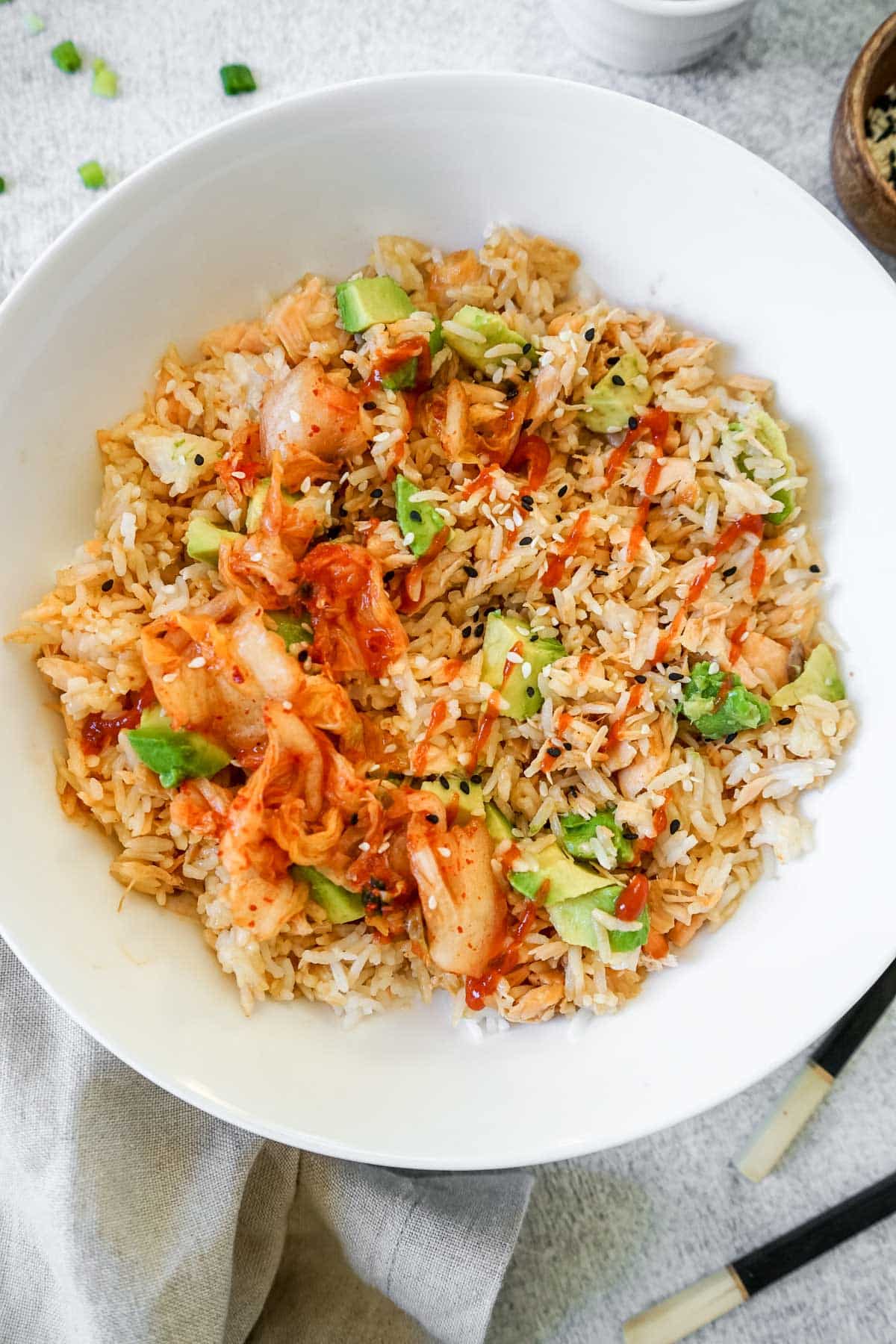 Tik Tok Salmon and Rice in a white bowl with kimchee and chop sticks.
