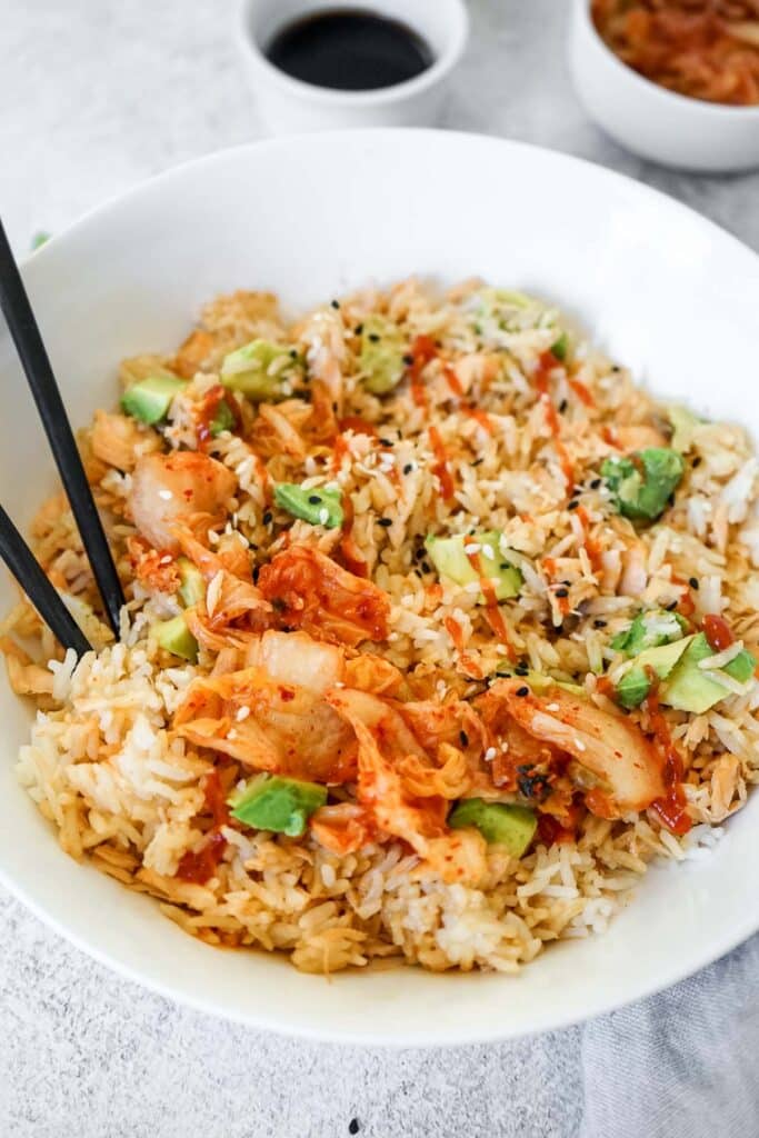 Salmon and rice bowl drizzle with hot sauce.