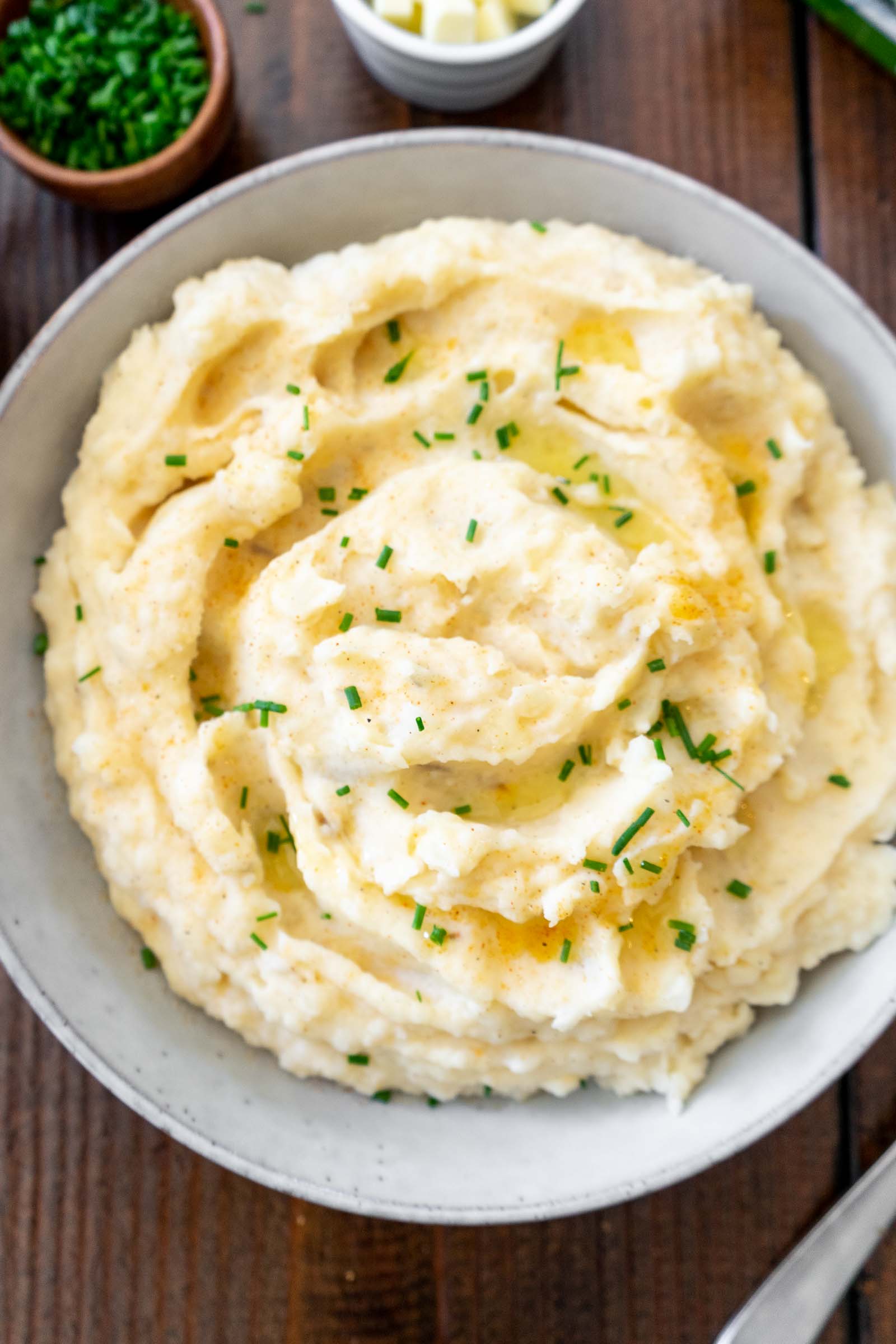 Mashed potatoes and gravy in a bowl sprinkled with chives.