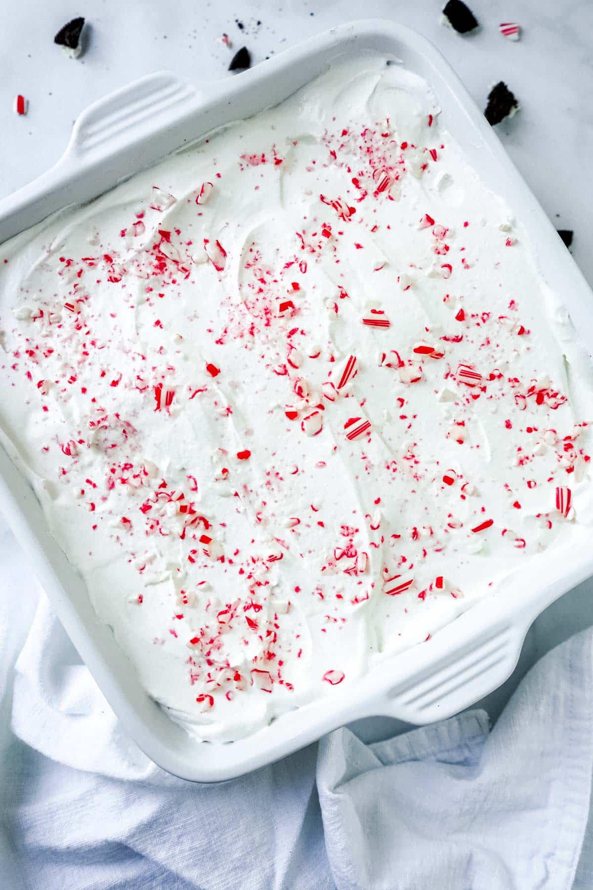 No bake chocolate peppermint pie in a baking pan topped with candy canes.