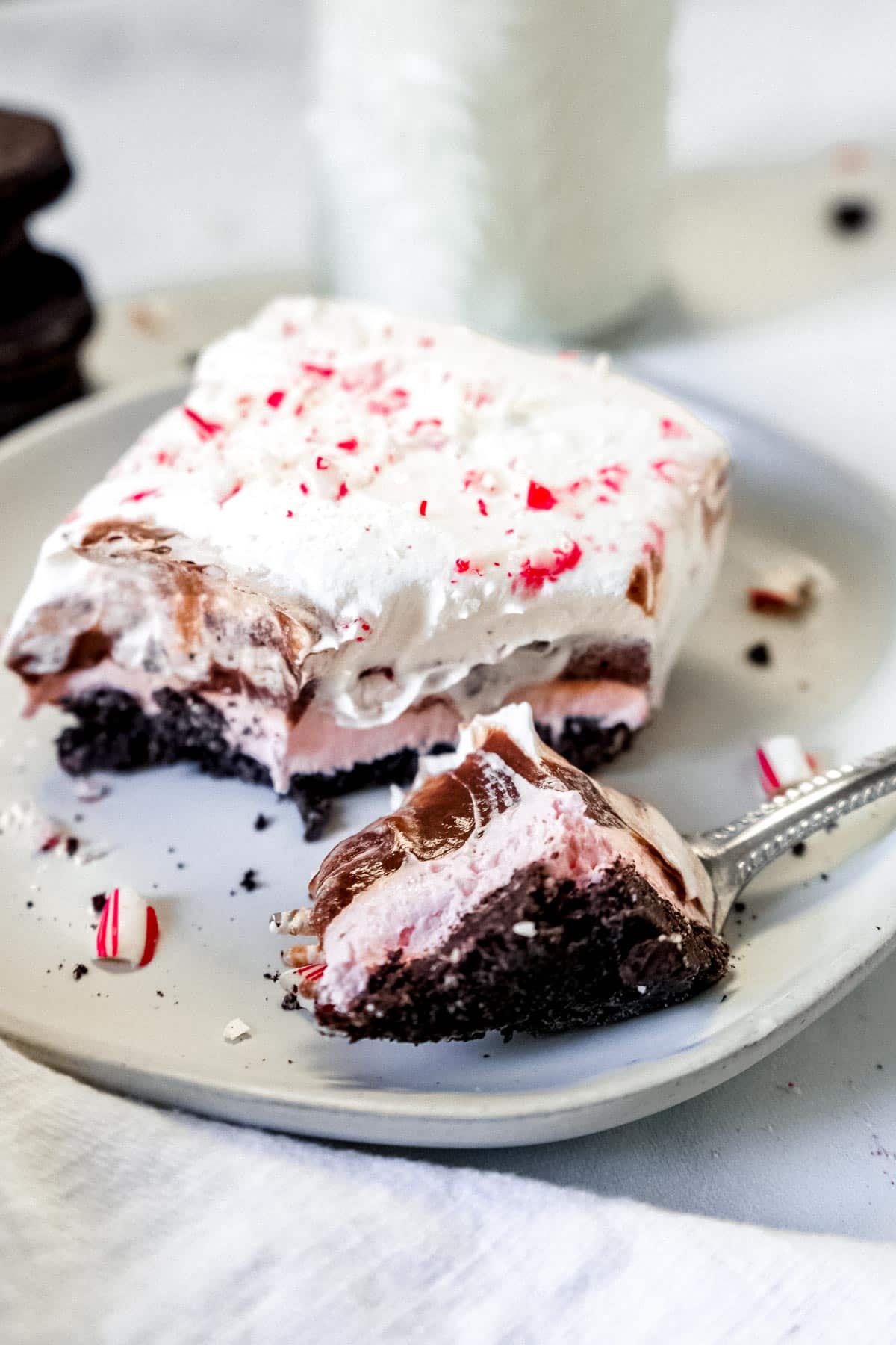 A piece of chocolate peppermint pie on a plate with a fork.