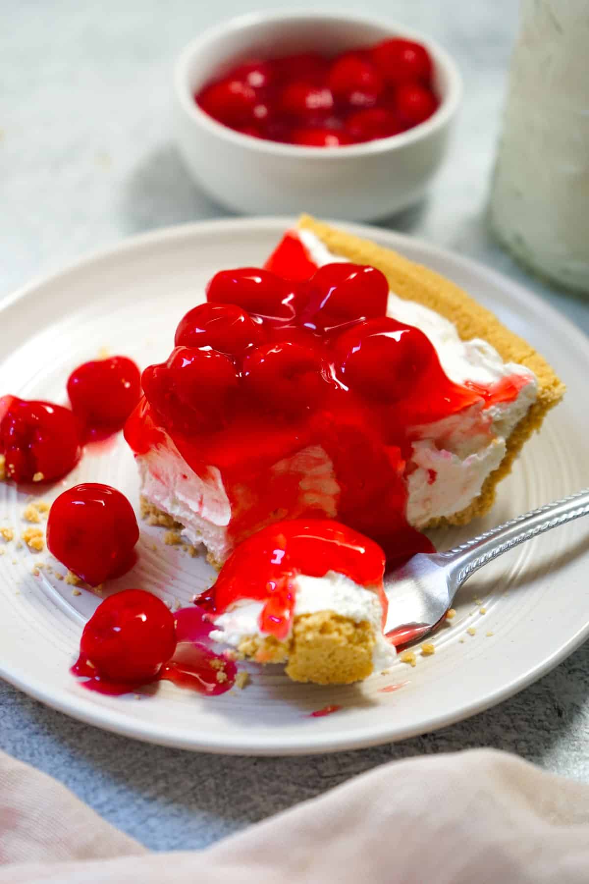 Cream Cheese Pie with cherry topping on a plate with a fork.