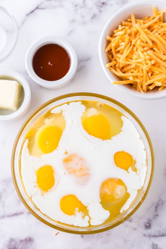 Raw eggs in a bowl with milk.