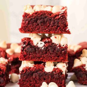 A stack of 3 red velvet brownies with white chocolate chips.