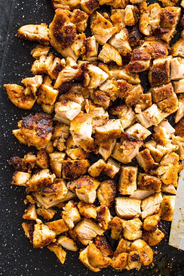 A cutting board of chopped, grilled chicken.