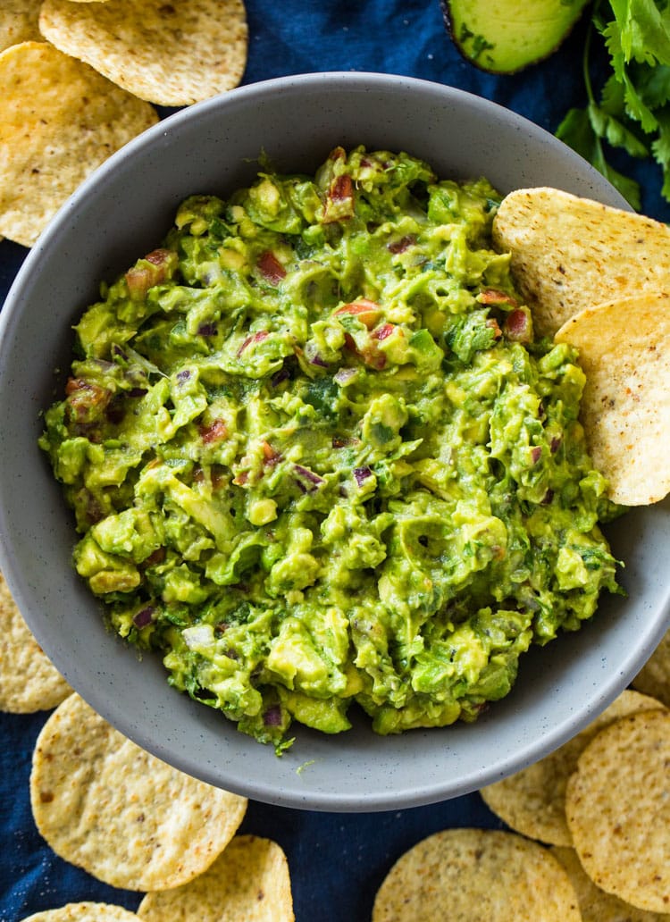 A big blue bowl of guacamole and chips -- the perfect side for nachos.