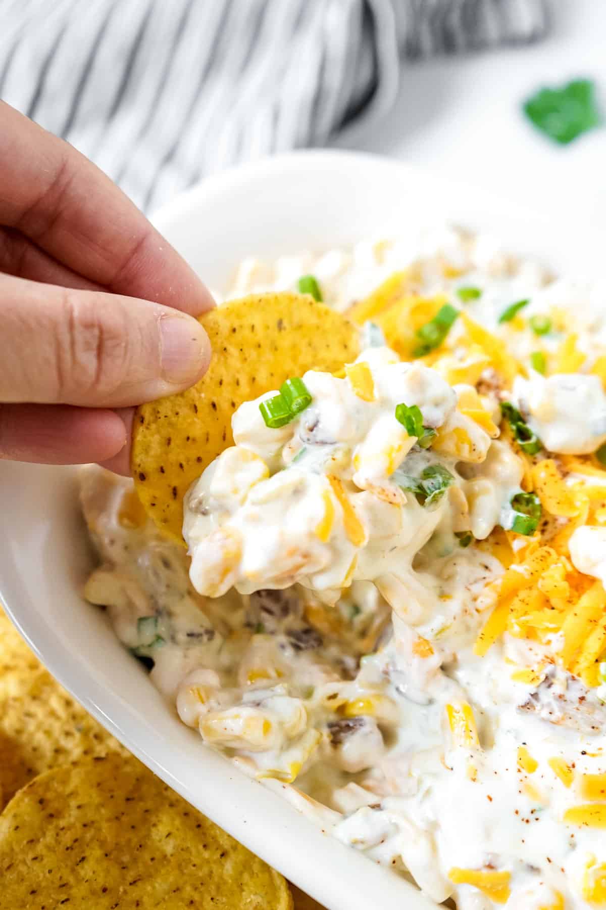 Cheesy bacon and corn crack dip pairs with with chips and nachos.