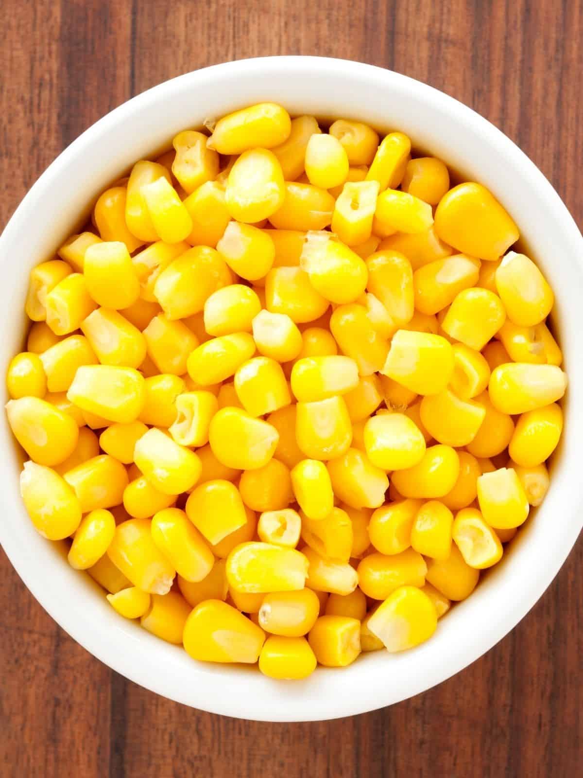 A large white bowl of yellow corn.