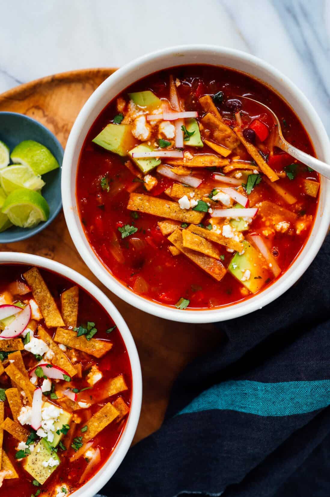 Bowl of tortilla soup with garnishes.