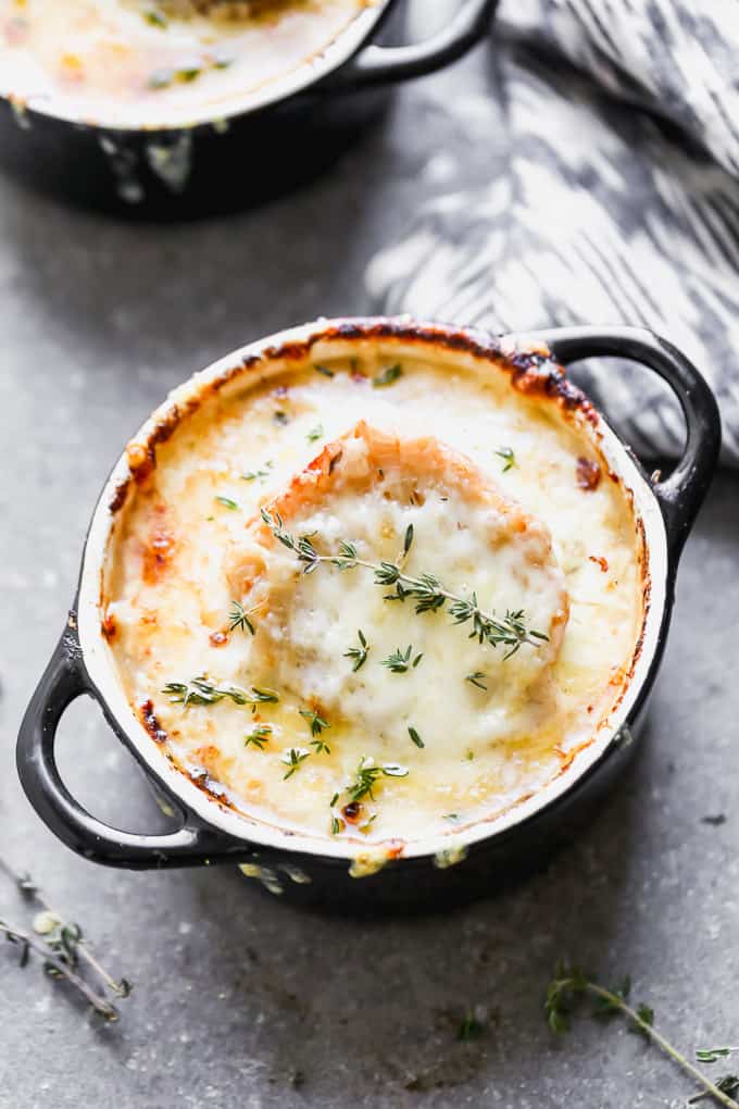 A small soup bowl with french onion soup, topped with cheese.