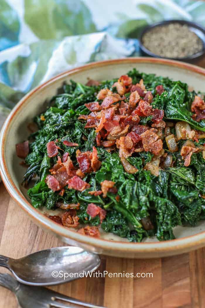 Sauteed kale in a bowl topped with bacon.