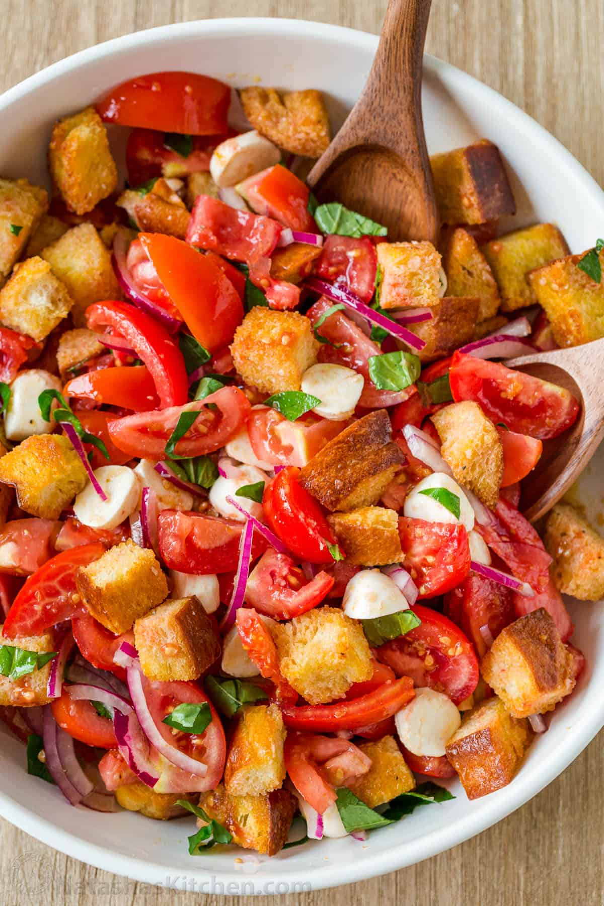 Panzanella salad in a large bowl with bread, tomatoes and herbs. 