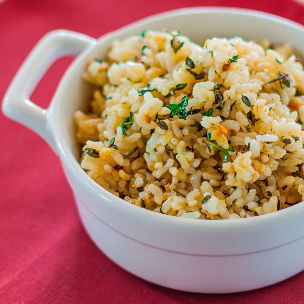 Brown rice with garlic and thyme in a white bowl. 