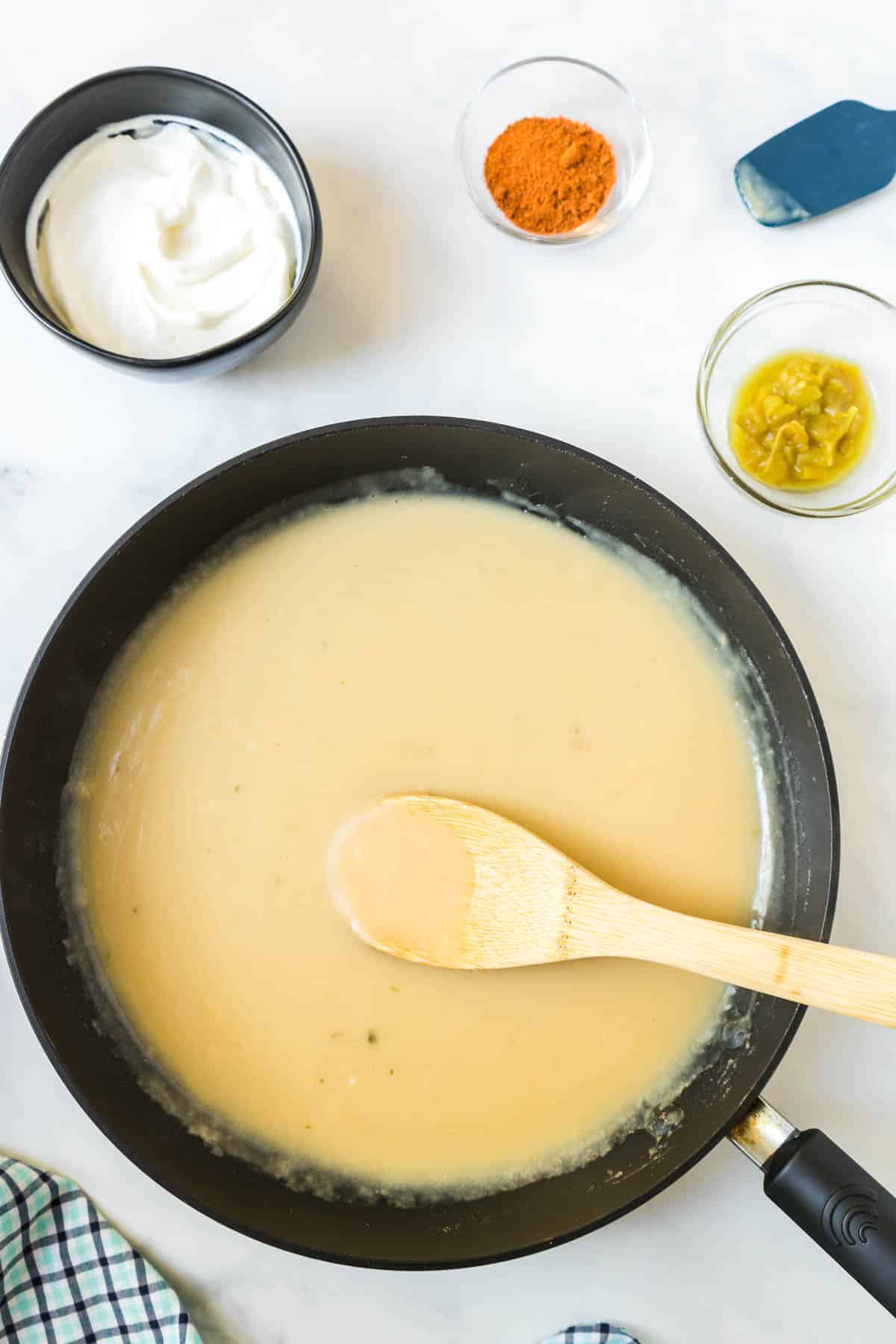 The sour cream sauce for the enchiladas in a large skillet.