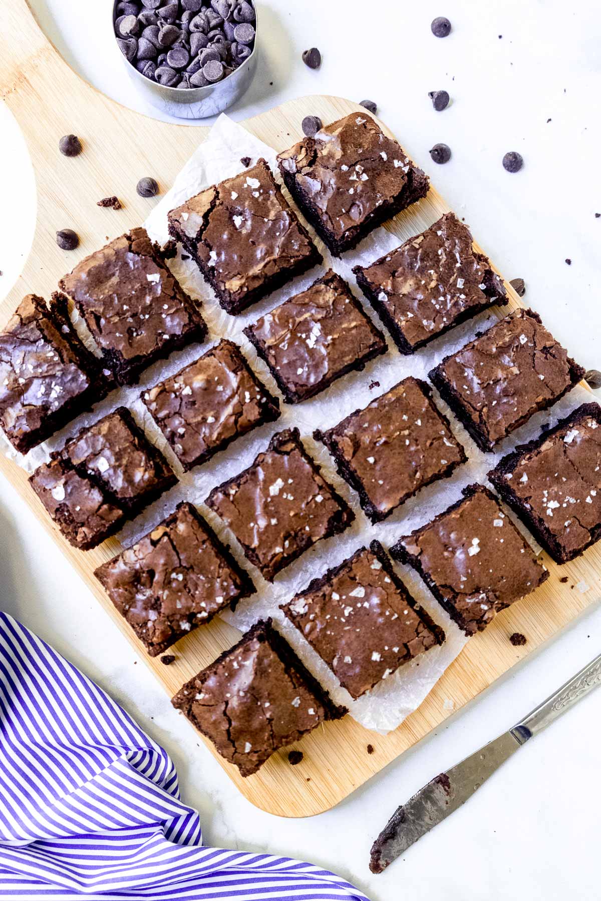 Brownies cut into squares with a blue and white striped linen.