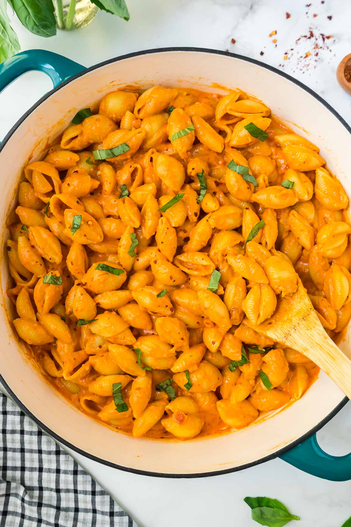 A large pan with Gigi Hadid Spicy Vodka pasta with a wooden spoon.