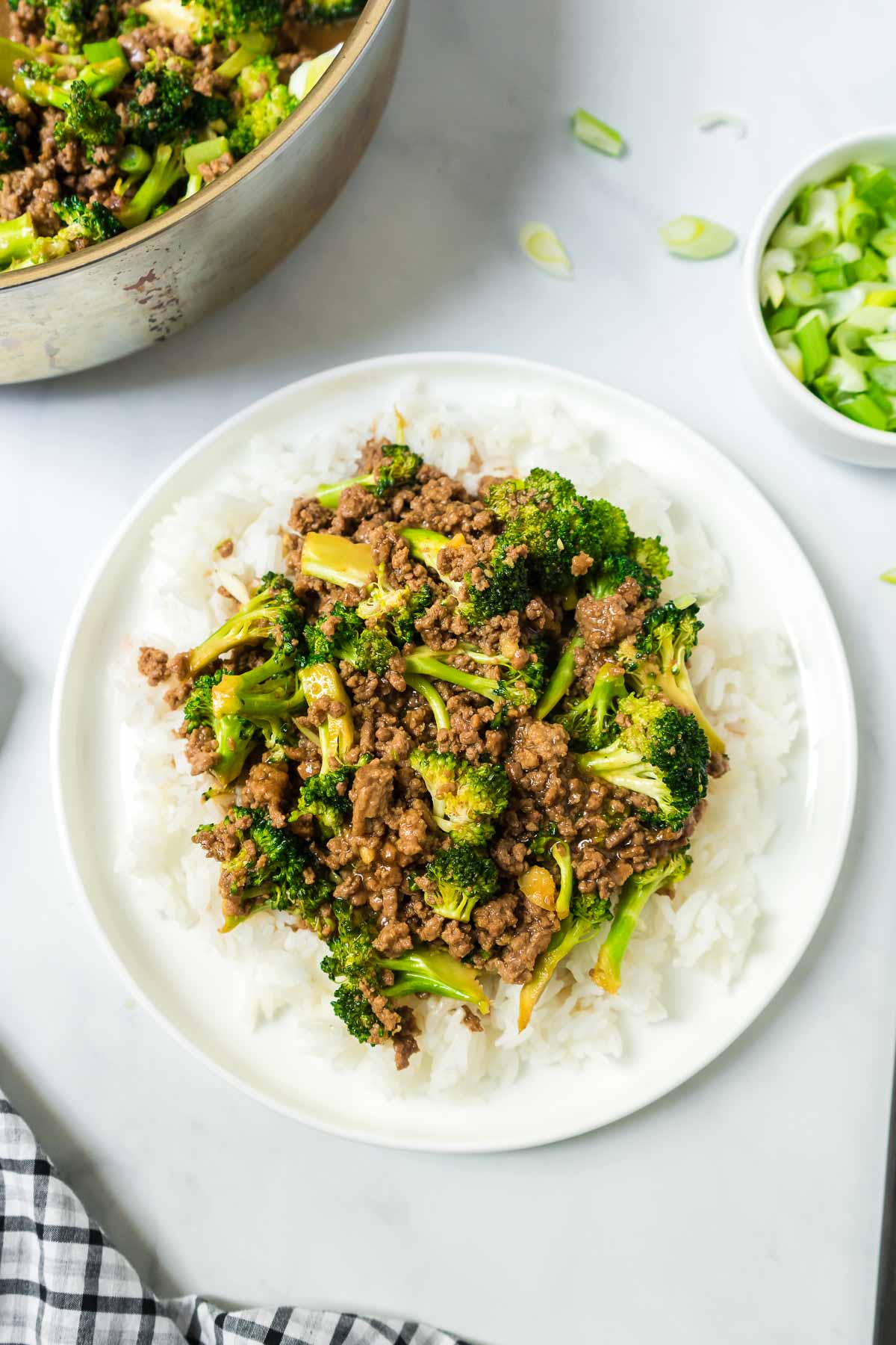 Healthy ground beef and broccoli on a white plate with chop sticks.
