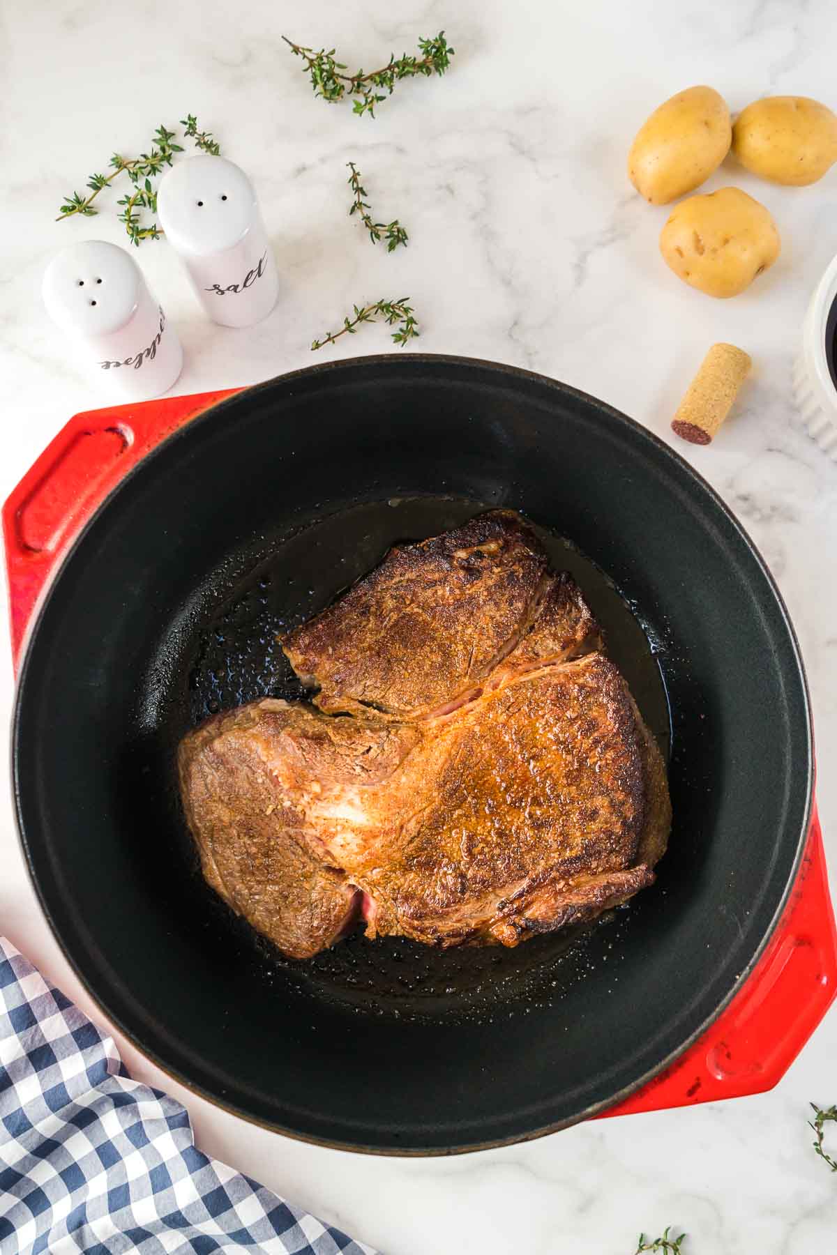 Chuck roast being seared in a dutch oven.