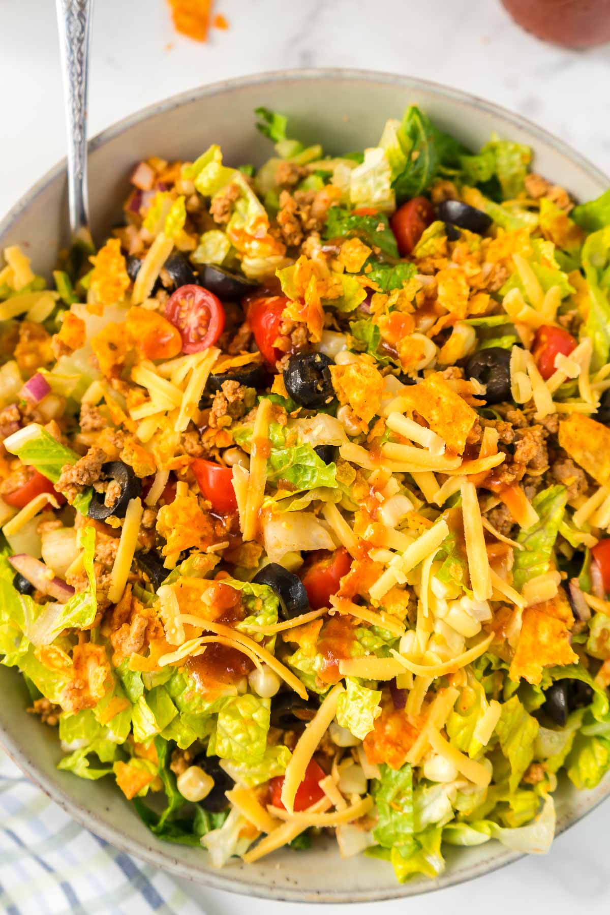 Taco Salad in a bowl drizzled with Catalina dressing.