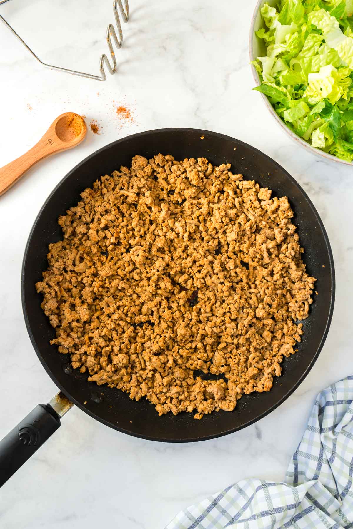 Ground turkey with taco seasoning being cooked in a large skillet.