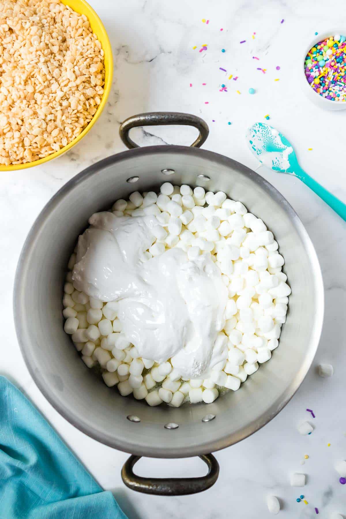 Marshmallow fluff and mini marshmallows in a large pan.
