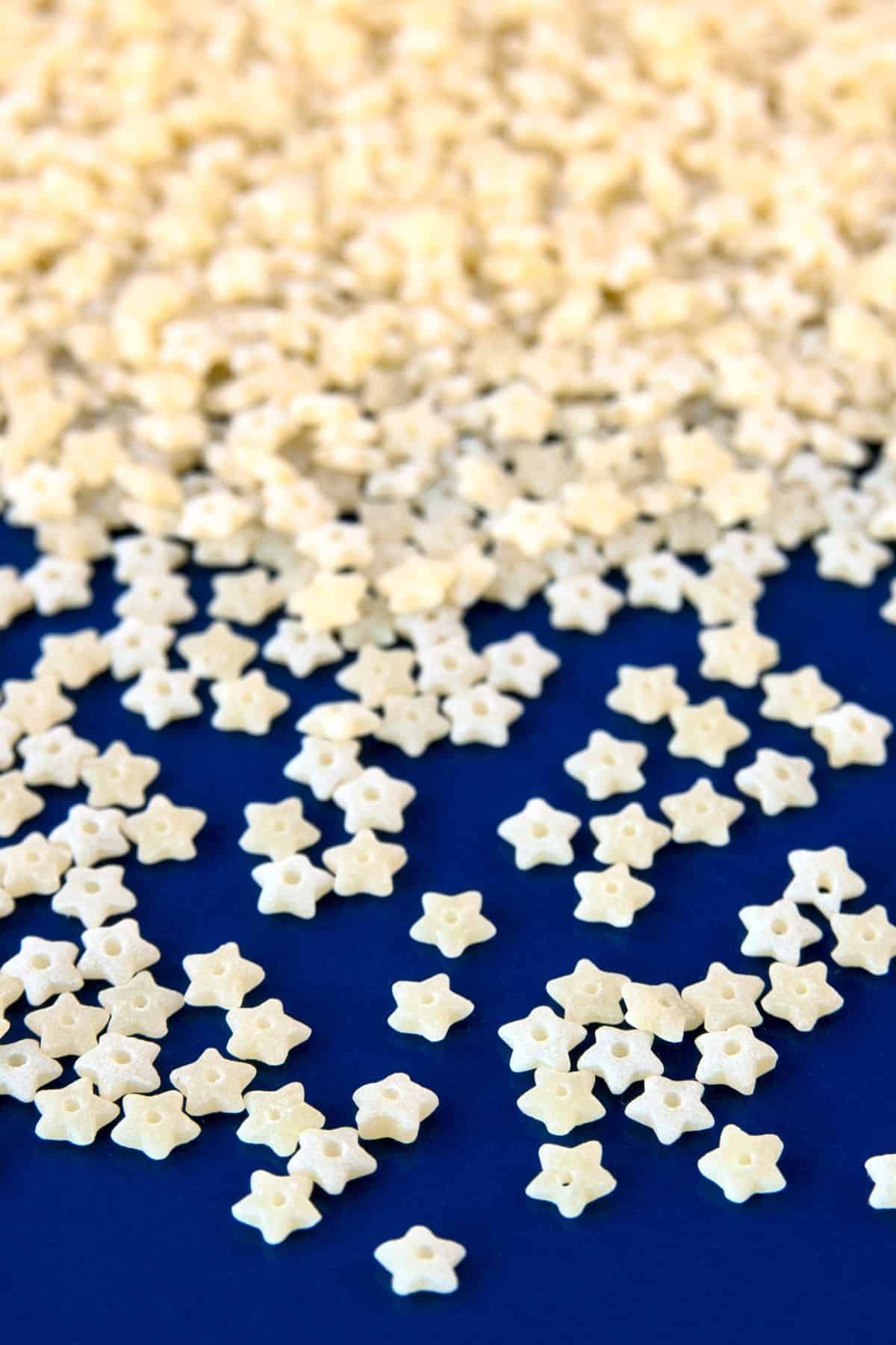 Steline pasta which is star shaped pasta on a blue background.