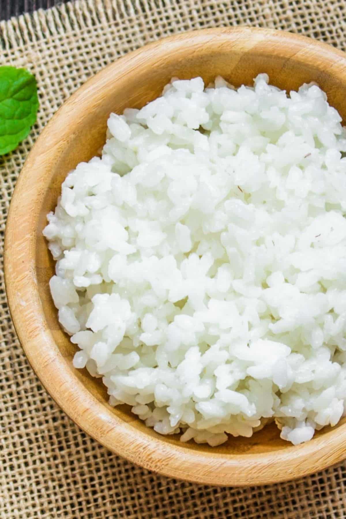 White rice in wooden bowl. In some dishes, white rice can be a good substitute for orzo.