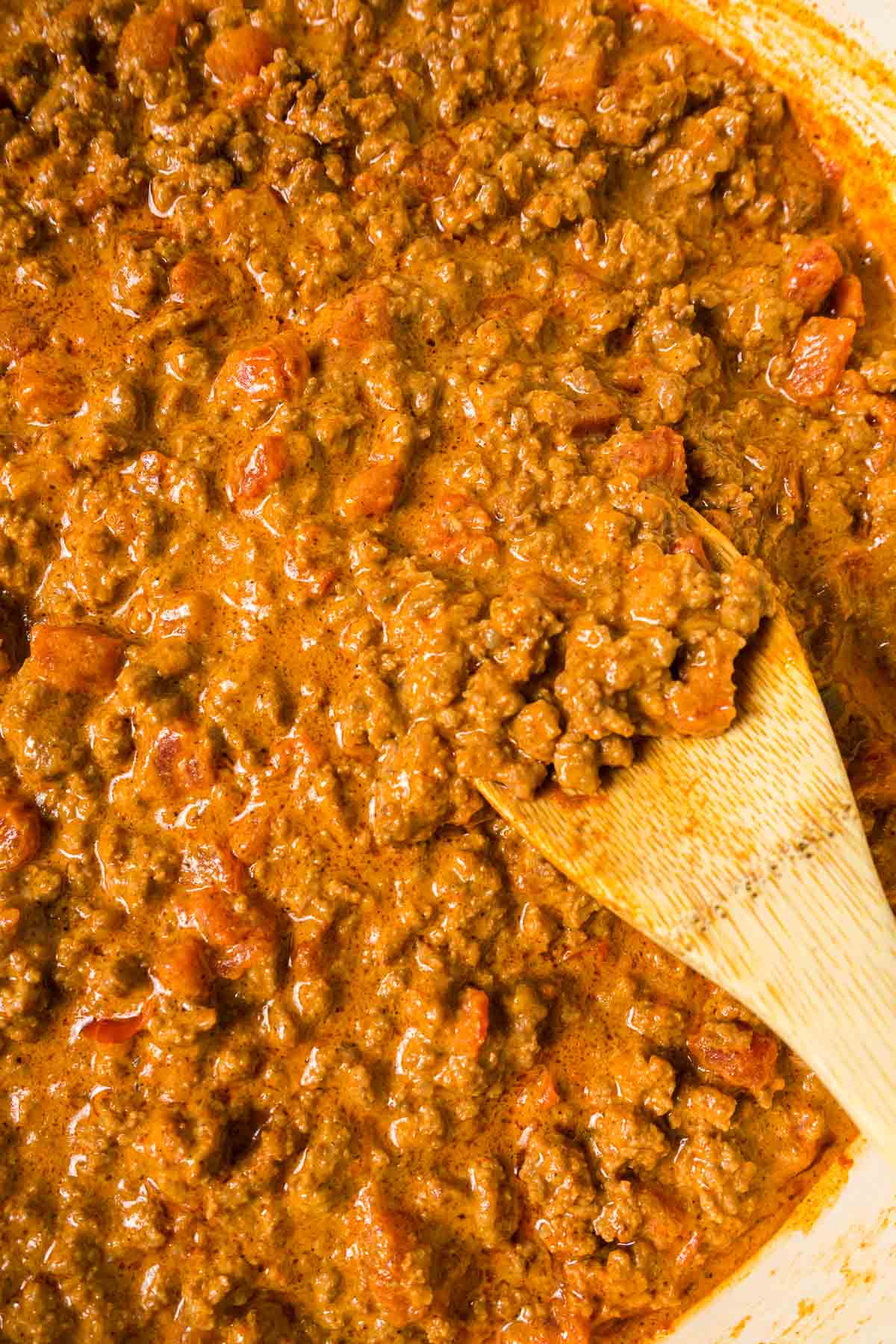 Close up of the cooked taco meat with a wooden spoon.
